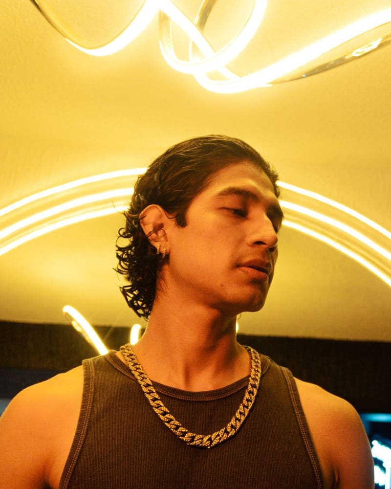 Gold Cuban chain worn under warm neon light