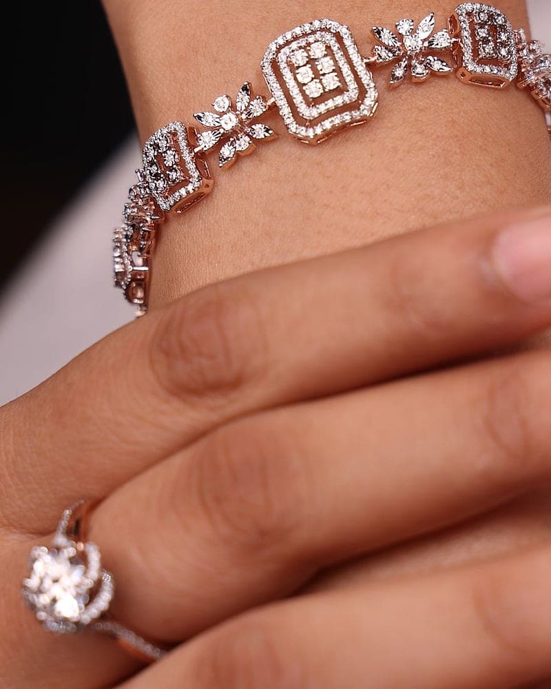 Rose gold diamond link bracelet and flower ring on the wrist