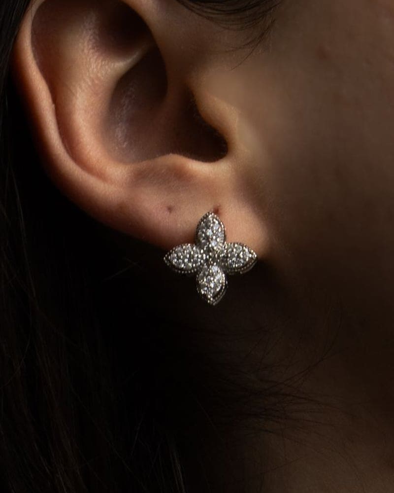 Star-shaped diamond stud earring worn against dark hair