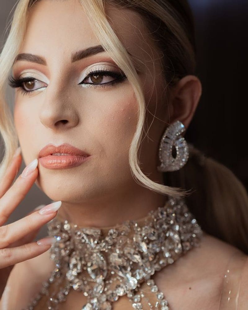Woman in evening makeup wearing a statement diamond collar necklace