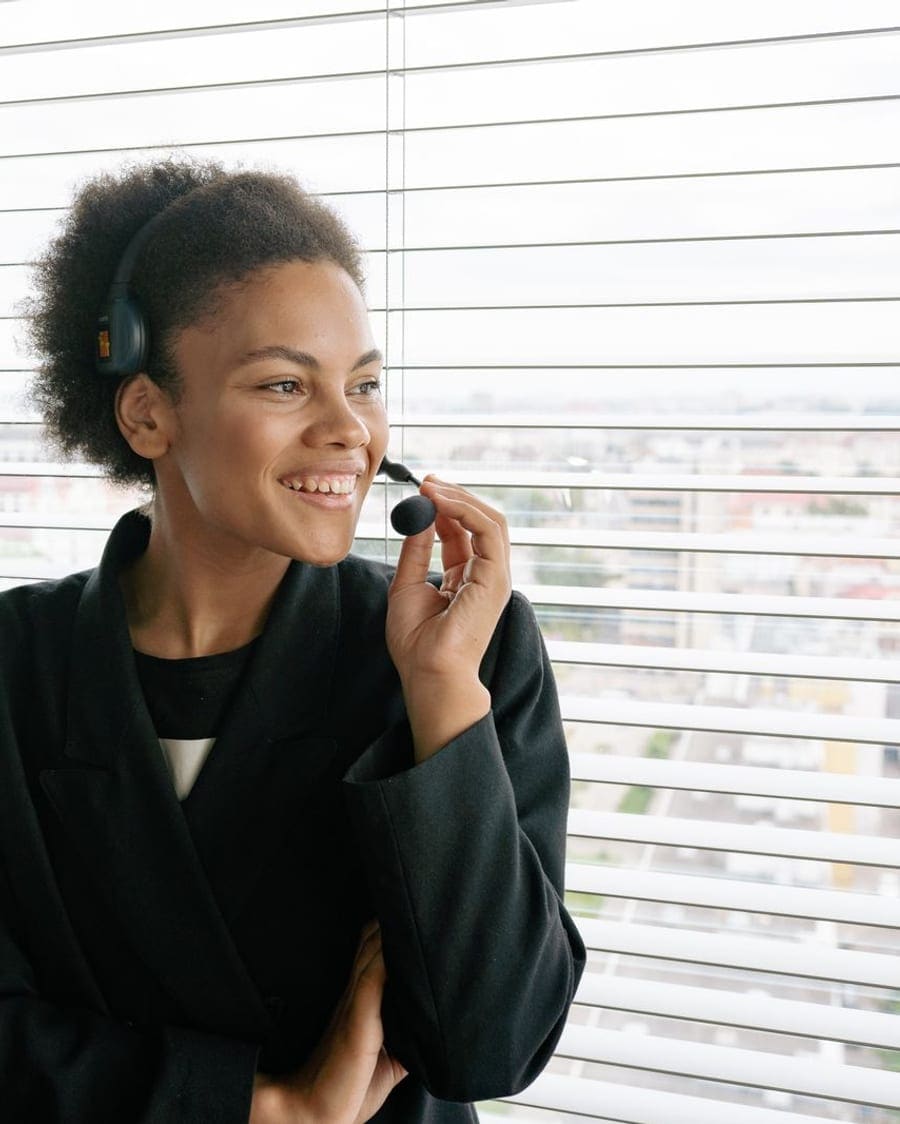 Smiling concierge wearing a headset by a bright window