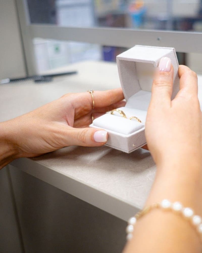 Jeweler presenting a ring box to a client across the counter