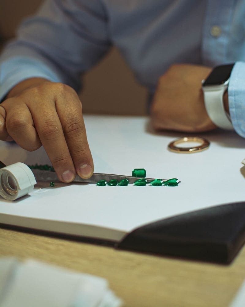 Jeweler inspecting loose gemstones on a sorting tray