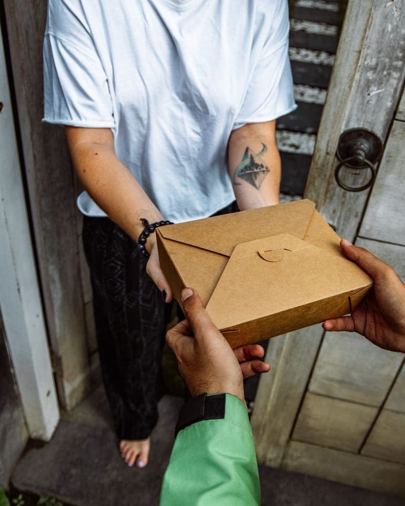 Parcel being handed over at a doorway for collection